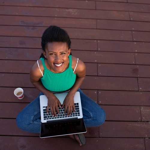 Woman working on laptop on stained deck