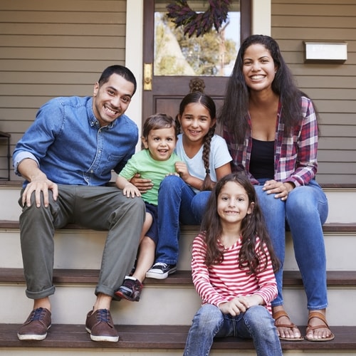Family sitting on a stained front porch